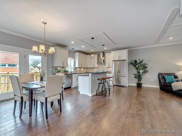 Inspiration for a large transitional l-shaped medium tone wood floor open concept kitchen remodel in Chicago with recessed-panel cabinets, white cabinets, quartzite countertops, gray backsplash, stainless steel appliances and an island