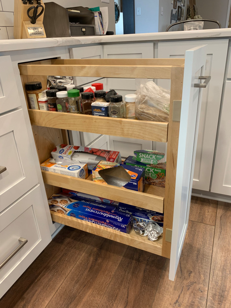 Inspiration for a large transitional u-shaped vinyl floor and brown floor open concept kitchen remodel with an undermount sink, shaker cabinets, white cabinets, quartz countertops, white backsplash, ceramic backsplash, stainless steel appliances, an island and white countertops