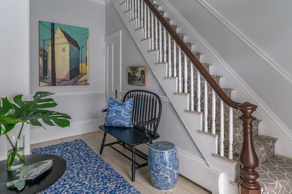 This is an example of a mid-sized beach style foyer in Boston with grey walls, painted wood floors and white floor.