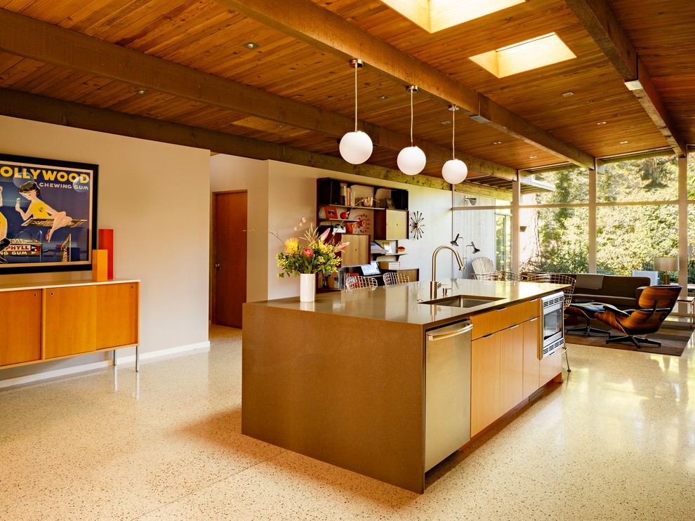 Photo of a mid-sized midcentury galley open plan kitchen in Portland with an undermount sink, flat-panel cabinets, medium wood cabinets, quartz benchtops, white splashback, ceramic splashback, stainless steel appliances, terrazzo floors, with island and multi-coloured floor.