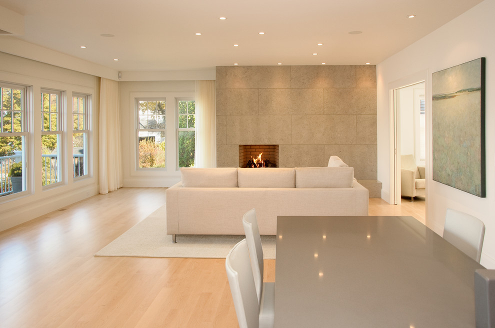 Photo of a modern living room in Portland Maine with white walls, a standard fireplace and beige floor.