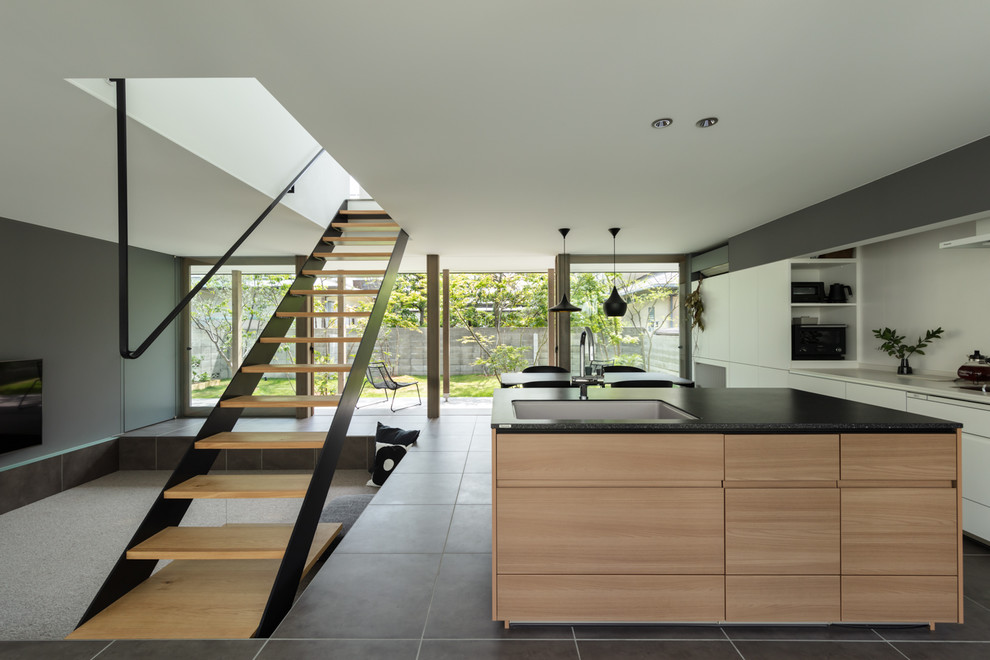 Design ideas for a l-shaped open plan kitchen in Other with an undermount sink, flat-panel cabinets, white cabinets, with island, black floor and black benchtop.