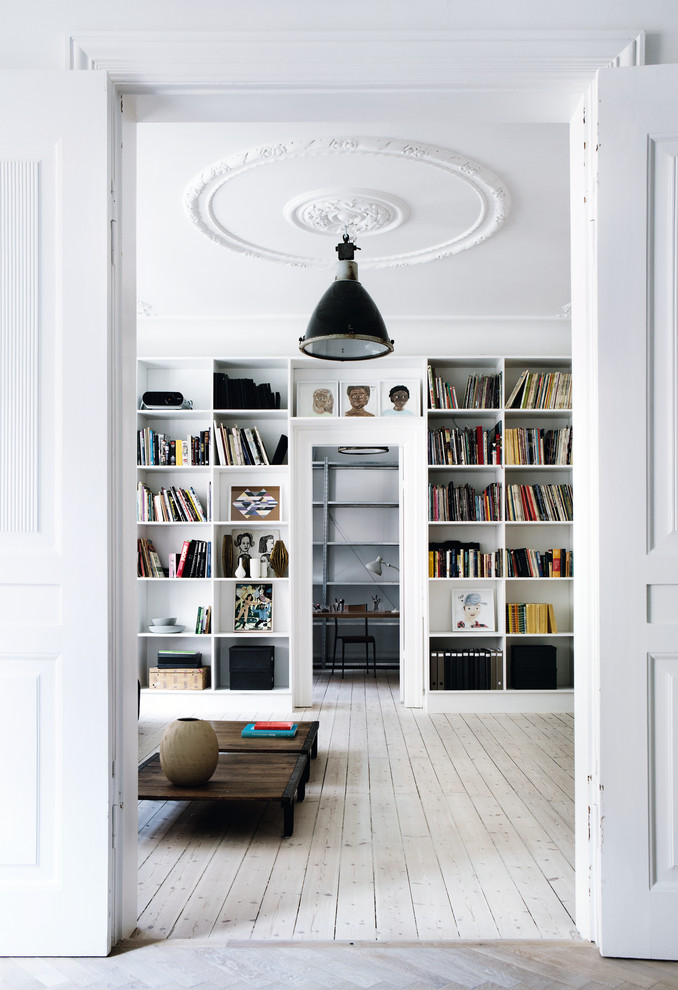 Große, Abgetrennte Skandinavische Bibliothek mit weißer Wandfarbe und hellem Holzboden in Sonstige