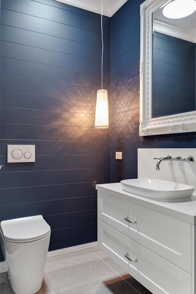 Bild på ett litet funkis vit vitt badrum med dusch, med vita skåp, en toalettstol med hel cisternkåpa, blå kakel, klinkergolv i keramik, ett nedsänkt handfat, bänkskiva i akrylsten och grått golv