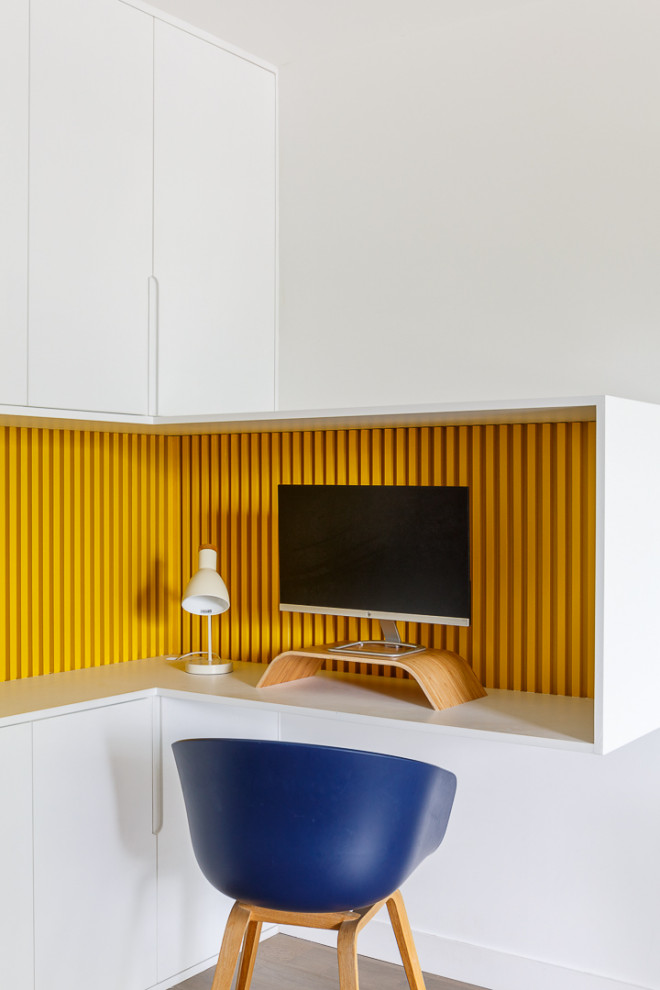 Foto de despacho contemporáneo de tamaño medio sin chimenea con paredes blancas, suelo de madera clara, escritorio empotrado y suelo beige