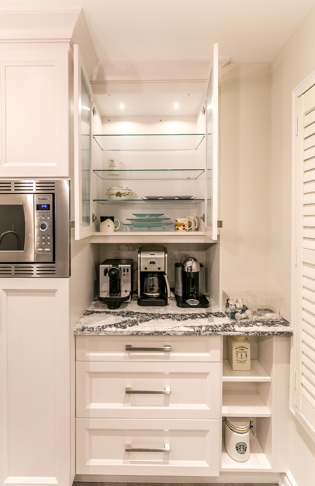 Large transitional gray floor enclosed kitchen photo in Toronto with an undermount sink, recessed-panel cabinets, white cabinets, quartz countertops, white backsplash, ceramic backsplash, stainless steel appliances and an island