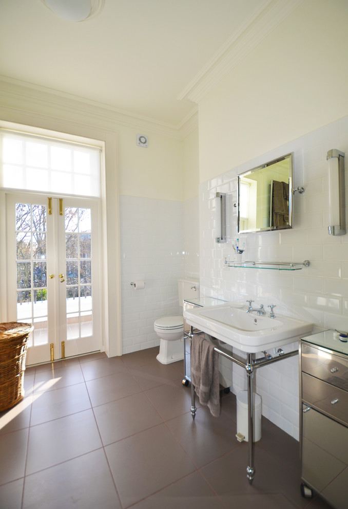 This is an example of a large contemporary master bathroom in London with furniture-like cabinets, white tile, ceramic tile, an undermount tub, a double shower, a two-piece toilet, a wall-mount sink, white walls and ceramic floors.