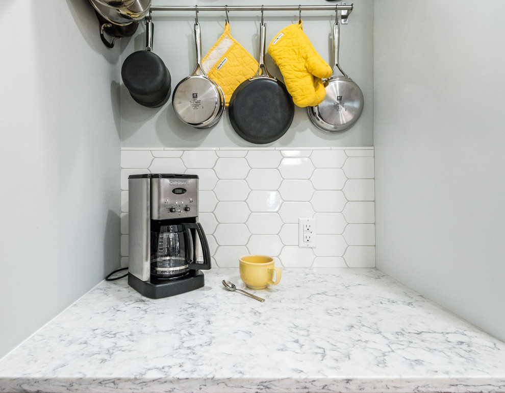 Example of a transitional medium tone wood floor kitchen design in Richmond with a single-bowl sink, shaker cabinets, white cabinets, quartzite countertops, white backsplash, mosaic tile backsplash, stainless steel appliances and a peninsula