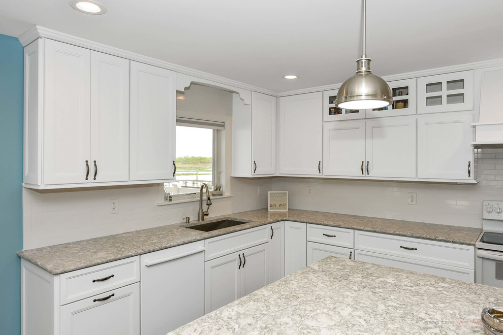 Large l-shaped eat-in kitchen in New York with an undermount sink, recessed-panel cabinets, white cabinets, quartz benchtops, white splashback, white appliances, with island and beige benchtop.