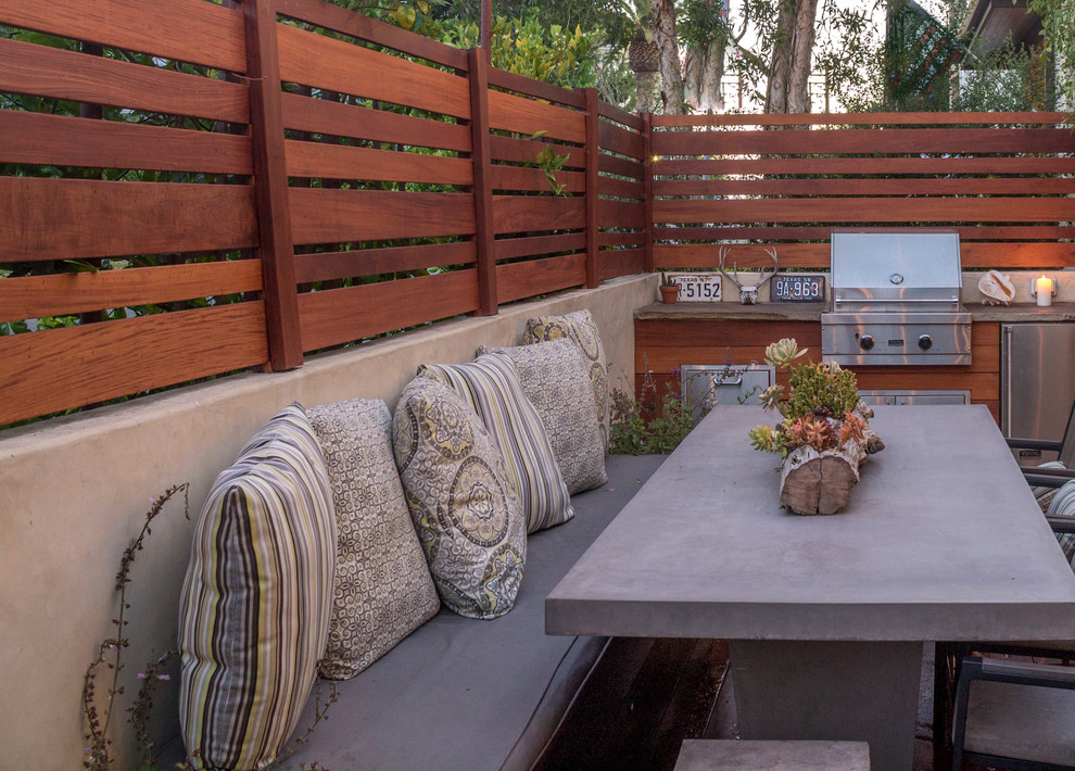 This is an example of a large modern backyard deck in Los Angeles with an outdoor kitchen.