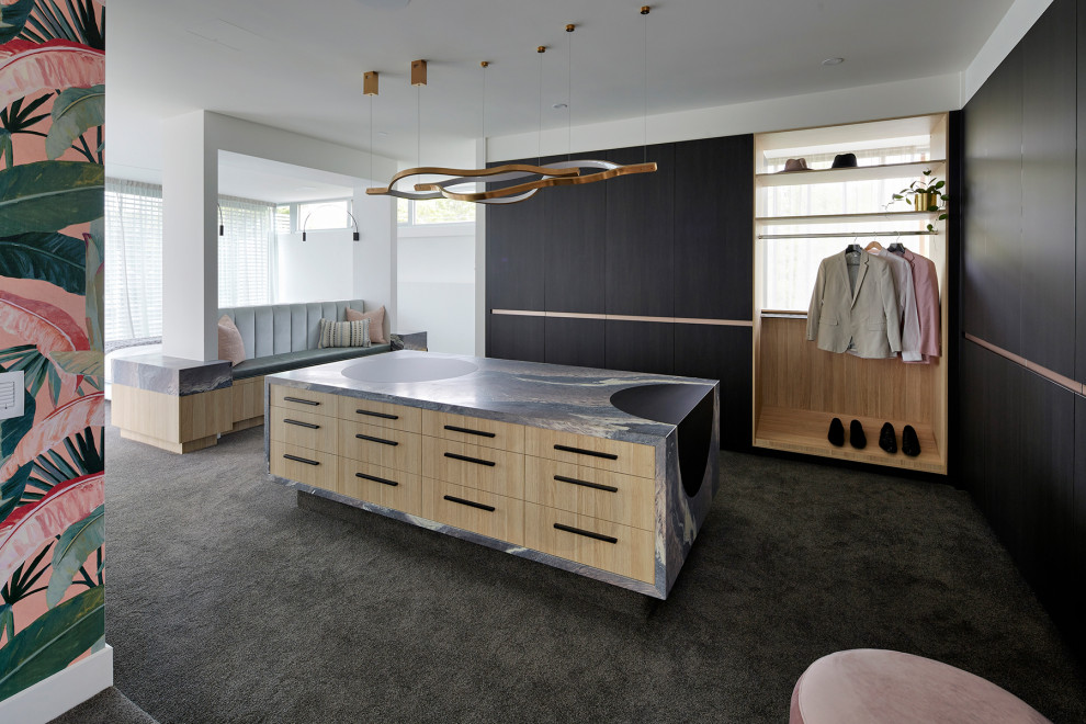 This is an example of a large contemporary gender-neutral walk-in wardrobe in Melbourne with black cabinets, carpet, grey floor and flat-panel cabinets.
