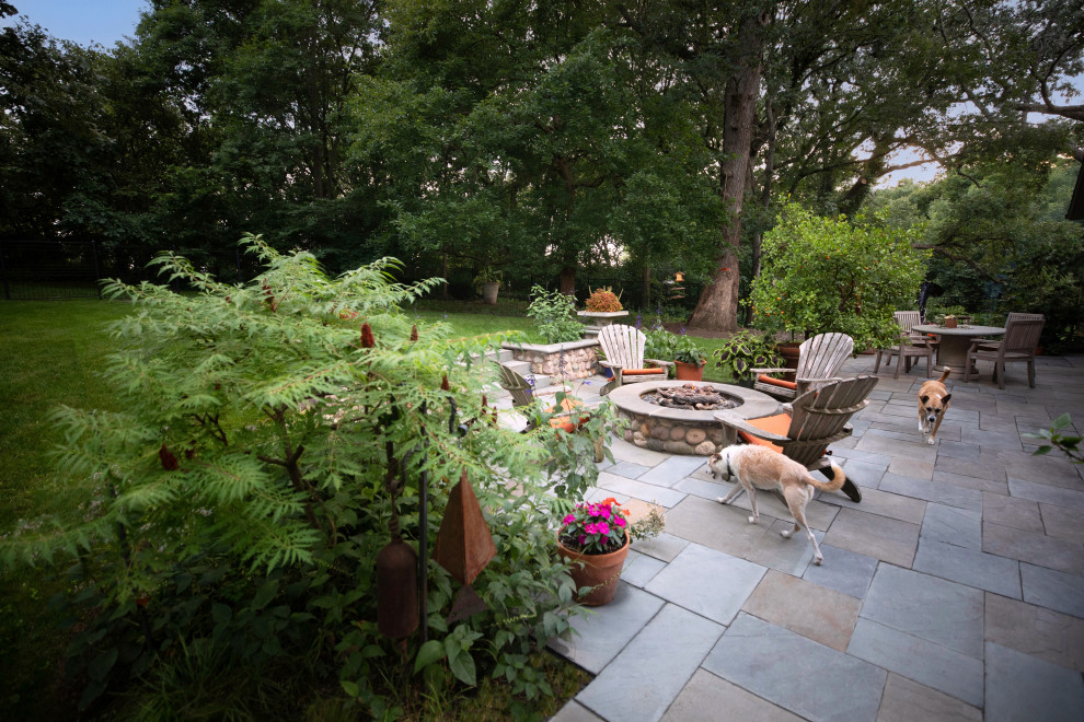 Immagine di un patio o portico american style di medie dimensioni e dietro casa con un focolare e pavimentazioni in pietra naturale