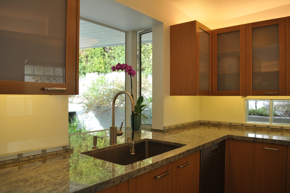 This is an example of a small traditional l-shaped eat-in kitchen in Los Angeles with a single-bowl sink, glass-front cabinets, medium wood cabinets, granite benchtops, grey splashback, glass tile splashback, stainless steel appliances, ceramic floors and no island.