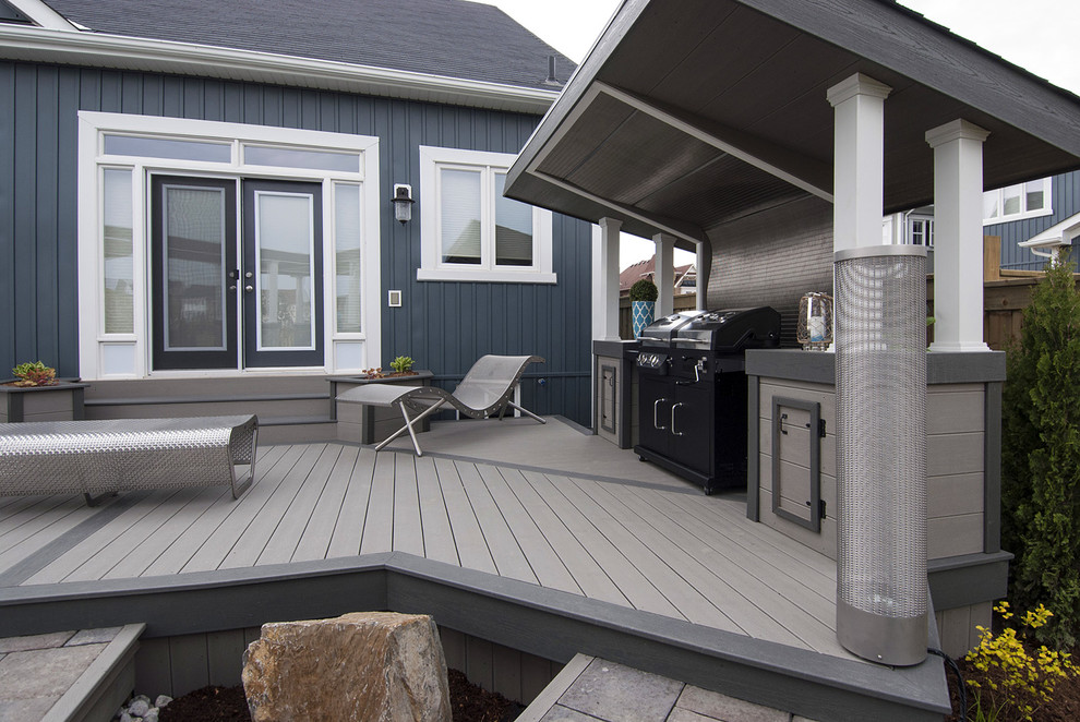 This is an example of a mid-sized industrial backyard deck in Toronto with a fire feature.