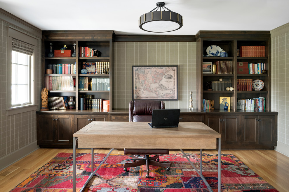 Transitional home office in Minneapolis with multi-coloured walls, light hardwood floors, no fireplace, a freestanding desk and a library.
