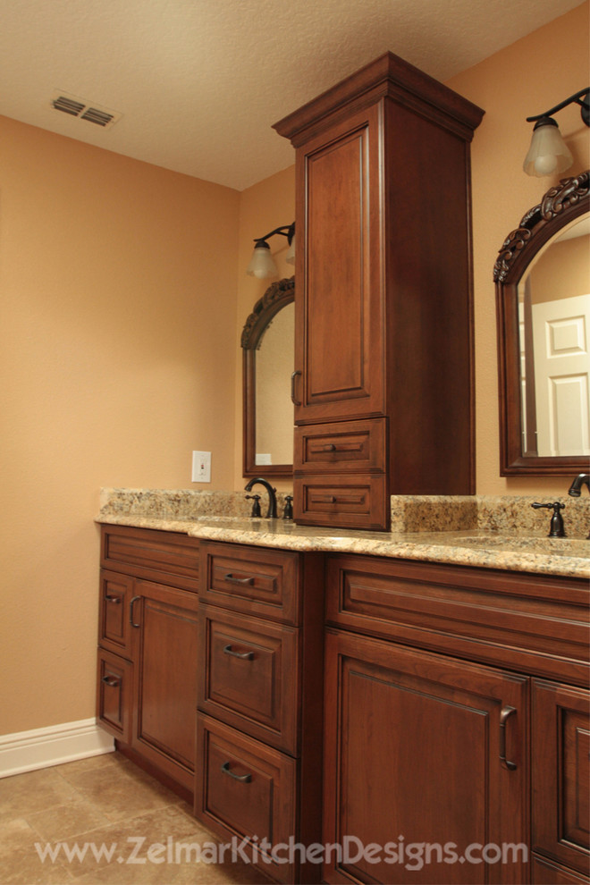 This is an example of a mid-sized traditional master bathroom in Orlando with an undermount sink, raised-panel cabinets, dark wood cabinets, granite benchtops, beige tile and stone tile.