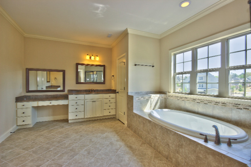 Modernes Badezimmer En Suite mit profilierten Schrankfronten, weißen Schränken, Einbaubadewanne, beigen Fliesen, Keramikfliesen, beiger Wandfarbe und Keramikboden in Raleigh