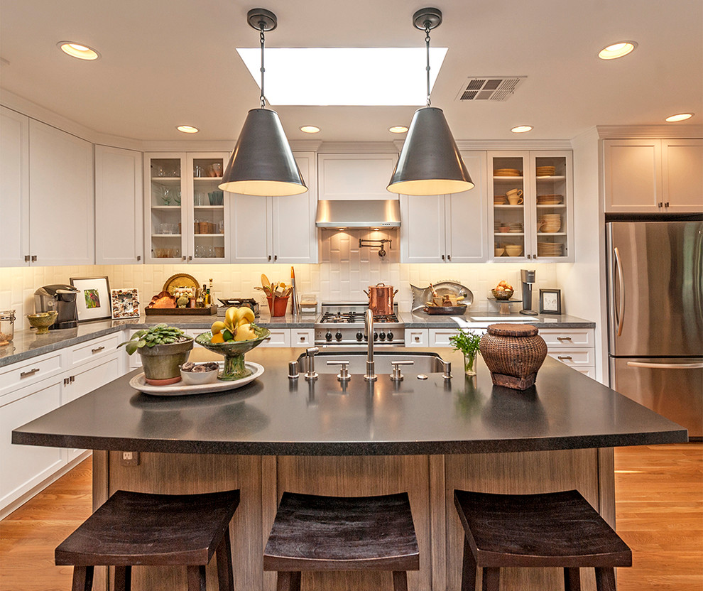 Inspiration for a traditional l-shaped open plan kitchen in Los Angeles with an undermount sink, shaker cabinets, white cabinets, white splashback, subway tile splashback, stainless steel appliances, medium hardwood floors and with island.
