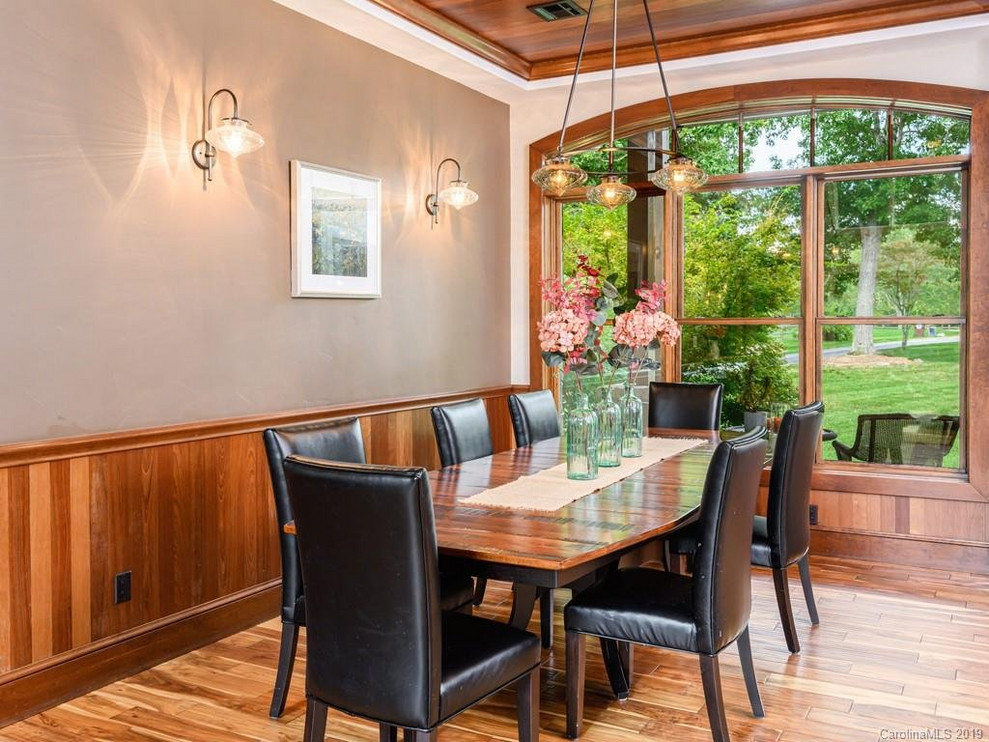 Large mountain style medium tone wood floor great room photo with beige walls