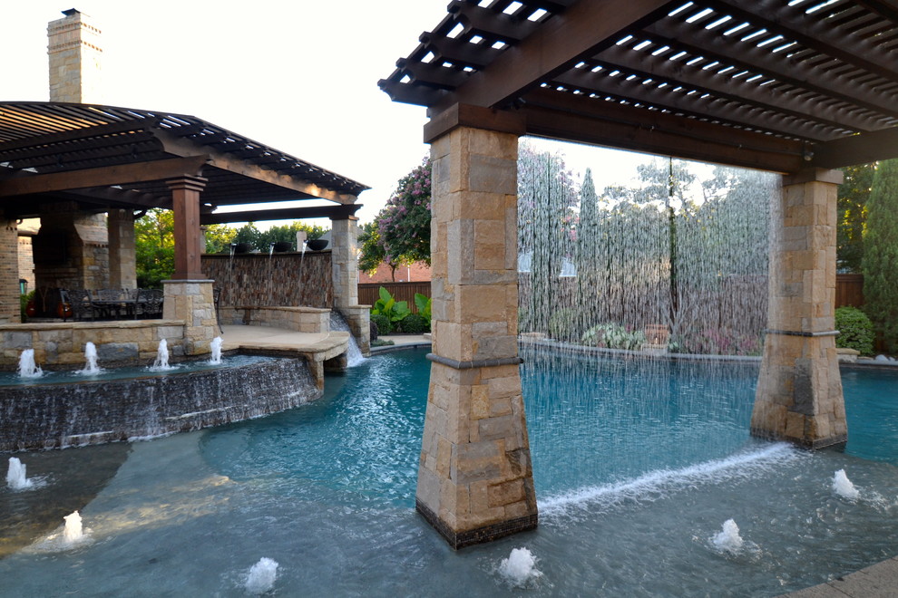 Design ideas for a large transitional backyard custom-shaped pool in Dallas with stamped concrete and a water feature.