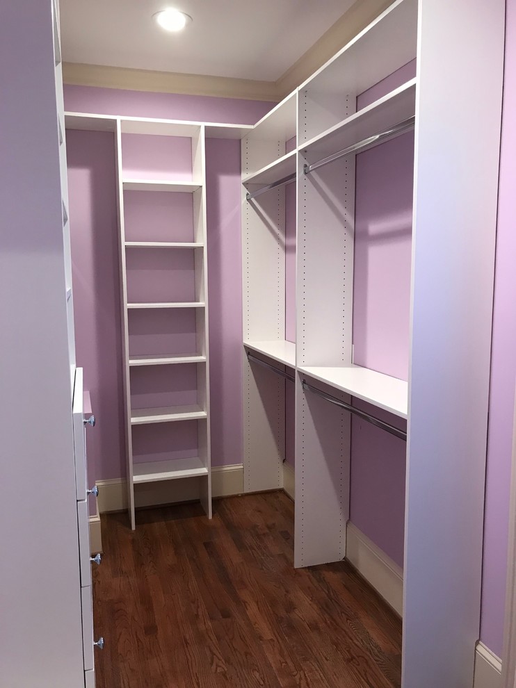 Walk-in closet - mid-sized traditional gender-neutral medium tone wood floor and brown floor walk-in closet idea with flat-panel cabinets and white cabinets