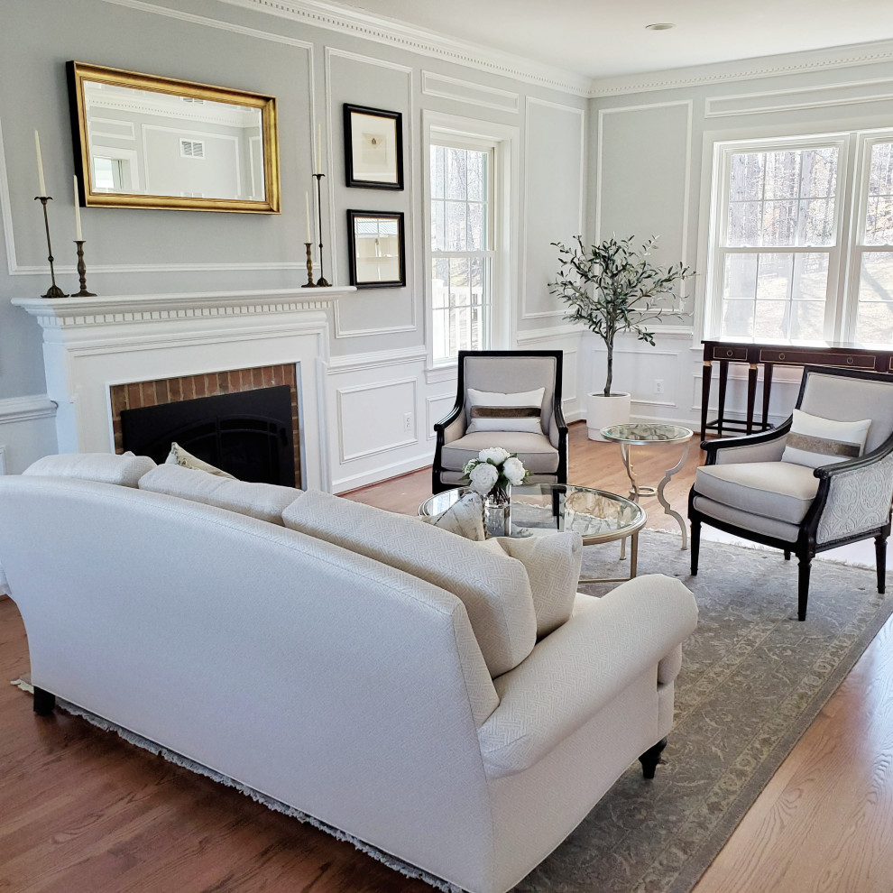 Large traditional formal enclosed living room in DC Metro with grey walls, medium hardwood floors, a standard fireplace, a brick fireplace surround and decorative wall panelling.