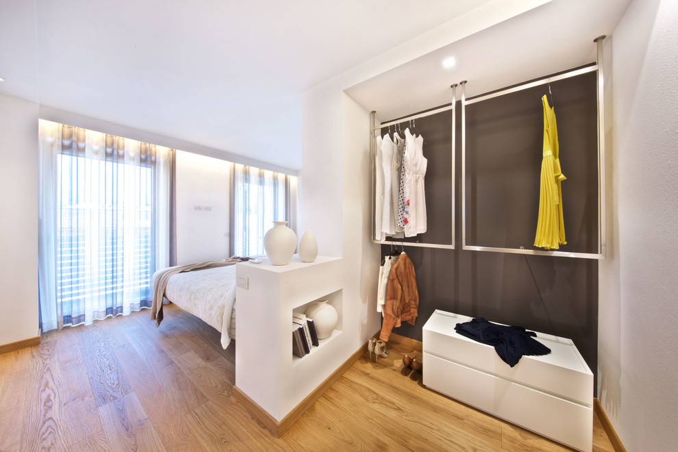 Photo of a small contemporary gender-neutral storage and wardrobe in Venice with open cabinets and medium hardwood floors.