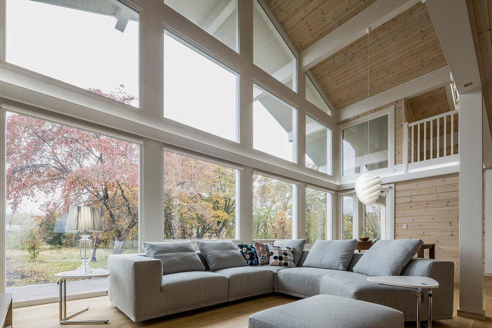 Photo of a scandinavian living room in Other with brown walls, light hardwood floors and brown floor.