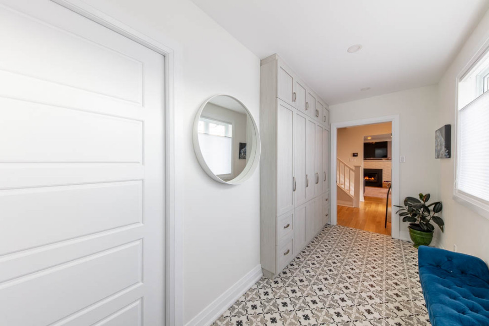 Mudroom - mid-sized transitional porcelain tile and gray floor mudroom idea in Ottawa with white walls and a white front door
