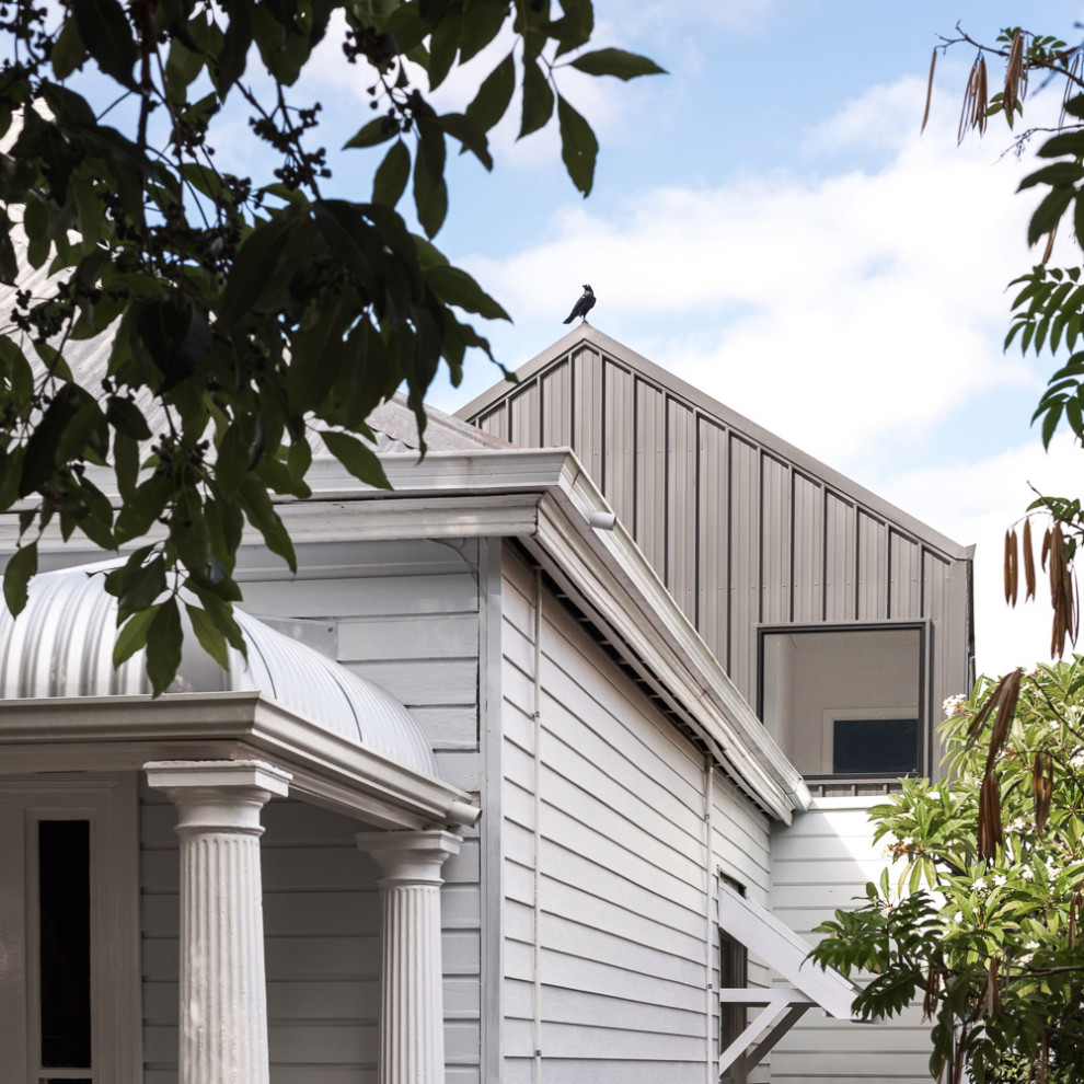 Idee per la facciata di una casa piccola bianca moderna a due piani con rivestimento in metallo, copertura in metallo o lamiera, tetto nero e pannelli e listelle di legno