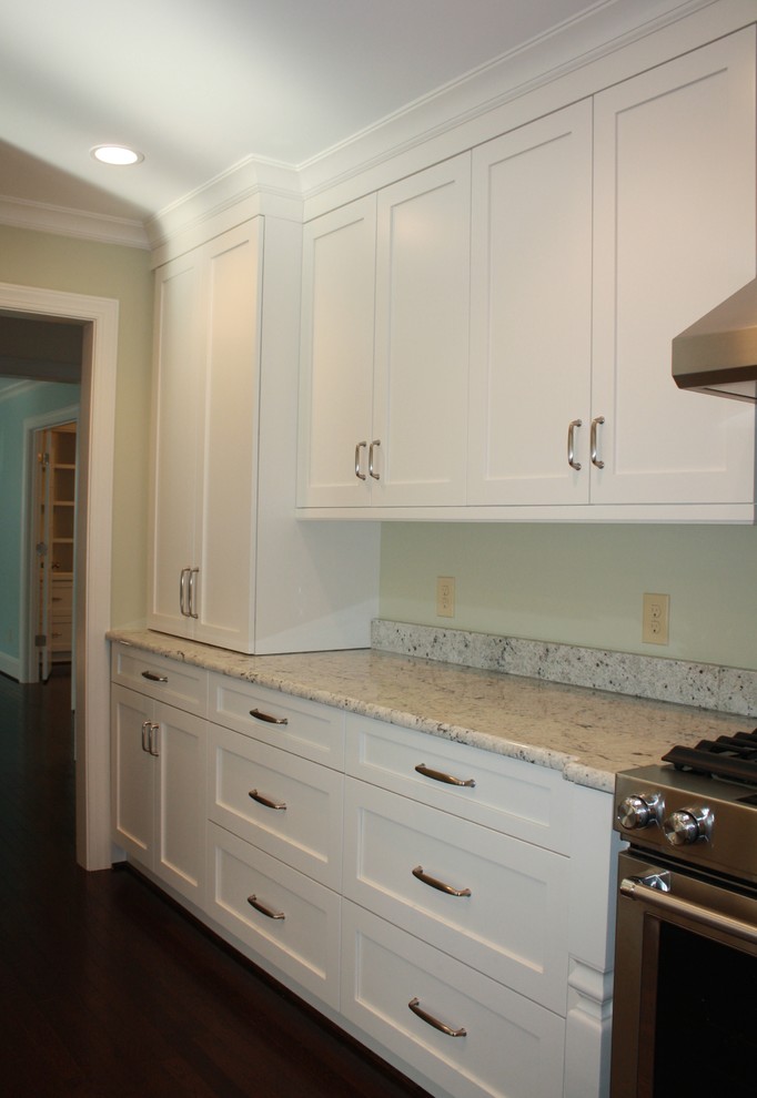 Inspiration for a transitional u-shaped dark wood floor kitchen remodel in Charlotte with recessed-panel cabinets, white cabinets, granite countertops, stainless steel appliances and an island