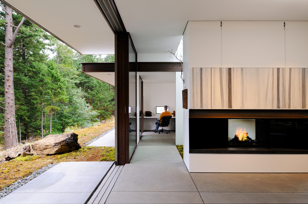 Photo of a mid-sized contemporary study room in Seattle with white walls, ceramic floors, a standard fireplace and a built-in desk.