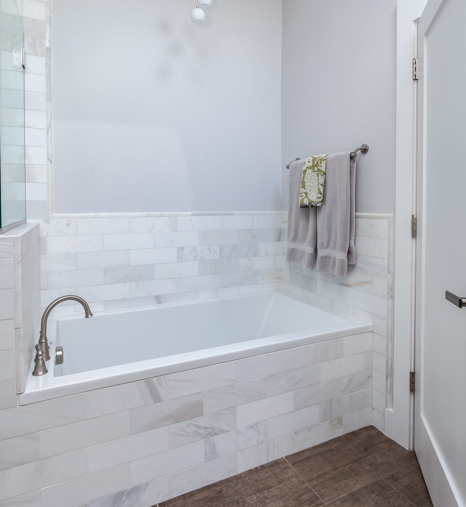 This is an example of a mid-sized modern master bathroom in Denver with shaker cabinets, white cabinets, a drop-in tub, white tile, white walls, medium hardwood floors, marble benchtops, a curbless shower and porcelain tile.