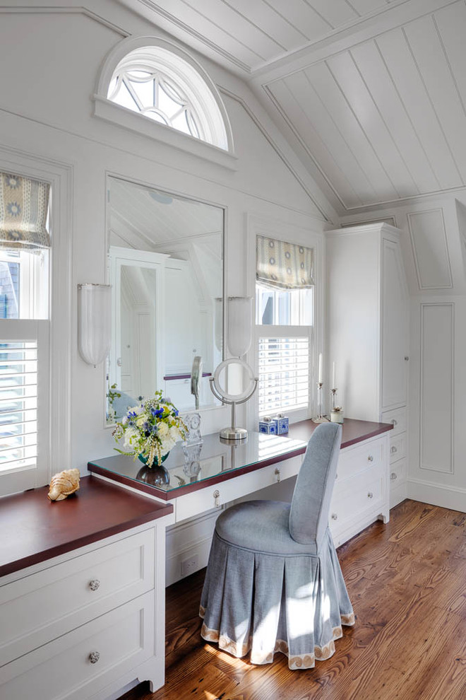 Inspiration for a mid-sized beach style women's walk-in wardrobe in Boston with white cabinets, medium hardwood floors and recessed-panel cabinets.