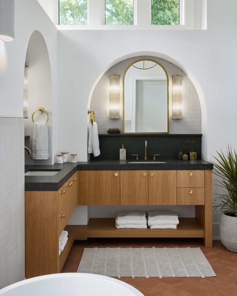 This is an example of a large contemporary master bathroom in Chicago with flat-panel cabinets, light wood cabinets, a freestanding tub, an alcove shower, gray tile, ceramic tile, white walls, cement tiles, engineered quartz benchtops, orange floor, a hinged shower door, grey benchtops, a shower seat, a double vanity, a built-in vanity and vaulted.