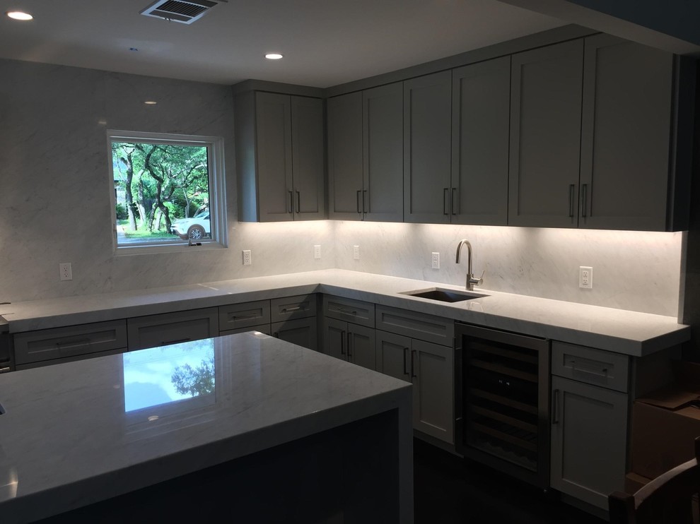 Eat-in kitchen - large modern eat-in kitchen idea in Austin with gray cabinets, quartz countertops, gray backsplash, stone slab backsplash, an island and gray countertops