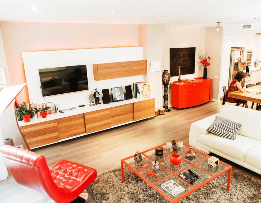 Imagen de salón abierto actual grande sin chimenea con paredes beige, suelo de madera en tonos medios y televisor colgado en la pared