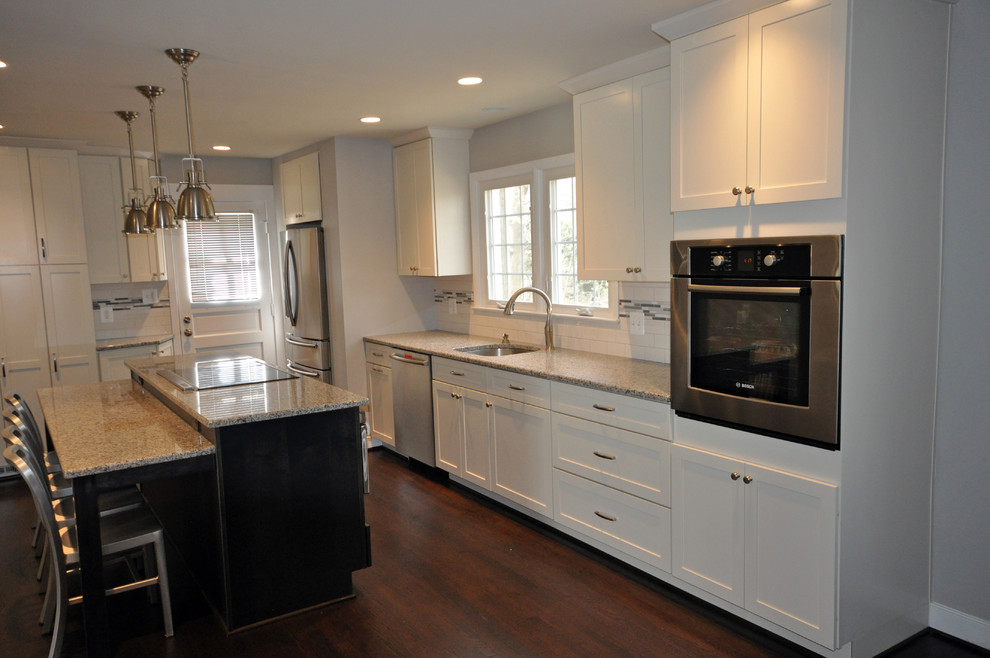 Inspiration for a mid-sized transitional l-shaped dark wood floor and brown floor open concept kitchen remodel in DC Metro with an undermount sink, shaker cabinets, white cabinets, white backsplash, subway tile backsplash, stainless steel appliances and an island