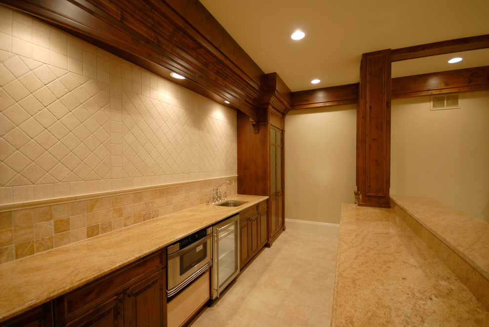 Inspiration for a mid-sized rustic galley ceramic tile and beige floor eat-in kitchen remodel in Birmingham with an undermount sink, raised-panel cabinets, dark wood cabinets, granite countertops, beige backsplash, ceramic backsplash, stainless steel appliances, an island and beige countertops