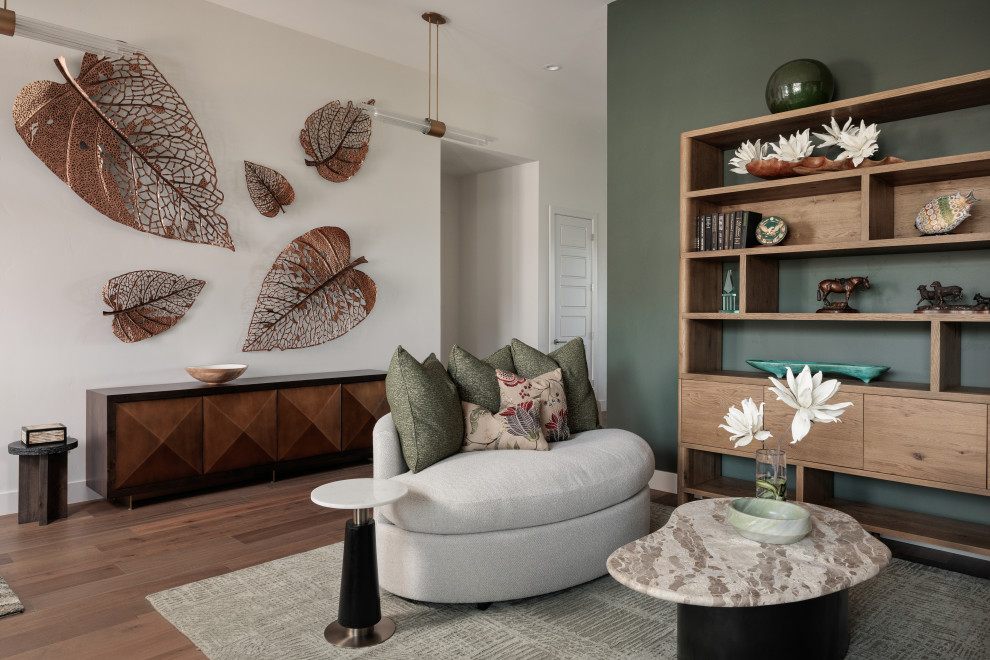 Example of a mid-sized transitional open concept medium tone wood floor and brown floor living room design with green walls, no fireplace and no tv