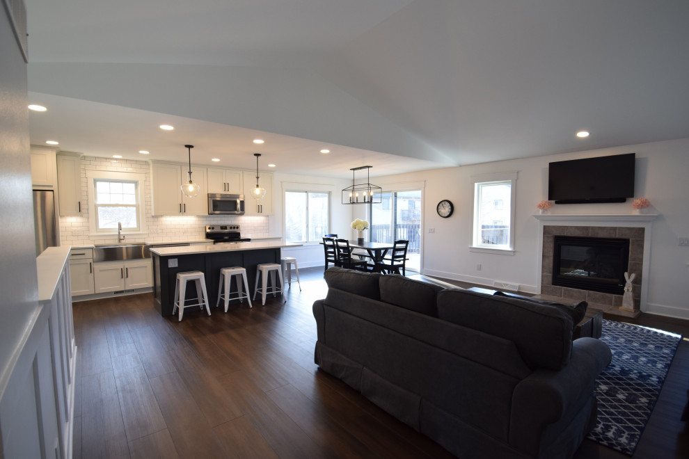 Inspiration for a mid-sized transitional single-wall vinyl floor open concept kitchen remodel with a farmhouse sink, shaker cabinets, quartz countertops, white backsplash, subway tile backsplash, stainless steel appliances, an island and white countertops