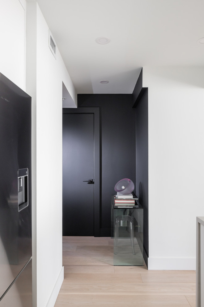 Inspiration for a small contemporary foyer in Vancouver with black walls, light hardwood floors, a single front door, a black front door and beige floor.