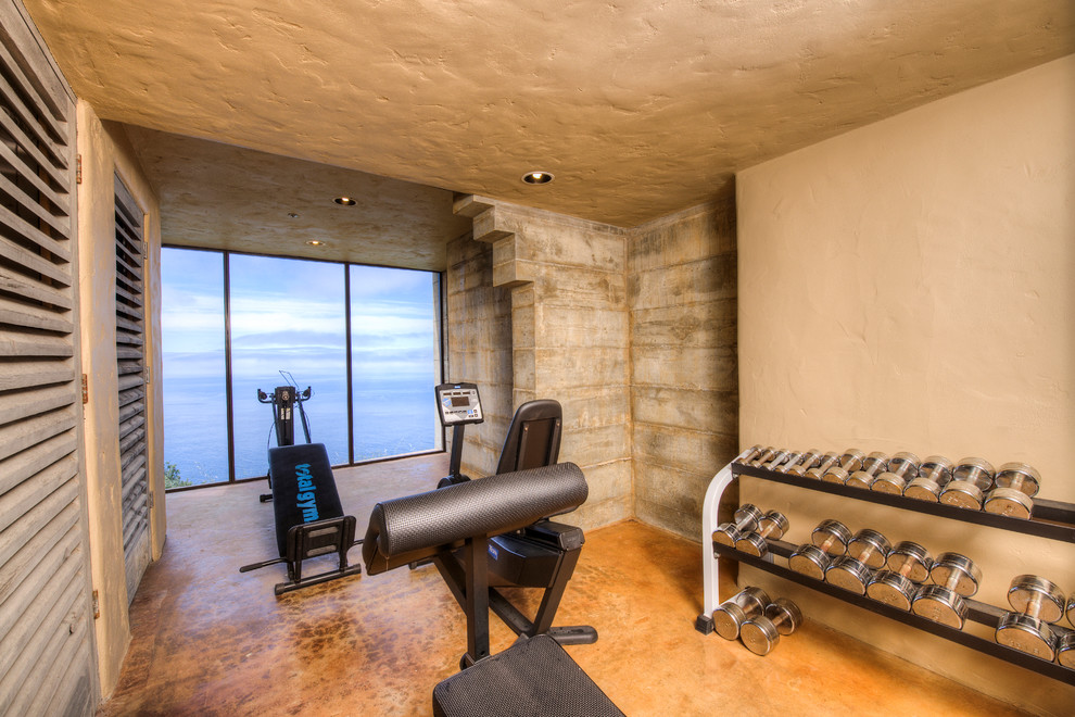Inspiration for a mid-sized mediterranean home weight room in San Francisco with beige walls and concrete floors.