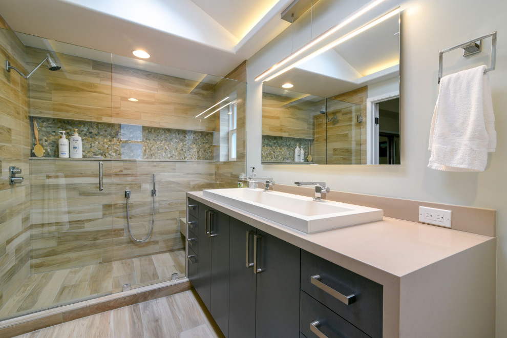 Mid-sized contemporary master bathroom in Santa Barbara with flat-panel cabinets, grey cabinets, an alcove shower, brown tile, porcelain tile, beige walls, porcelain floors, a trough sink, engineered quartz benchtops, beige floor, a hinged shower door and beige benchtops.