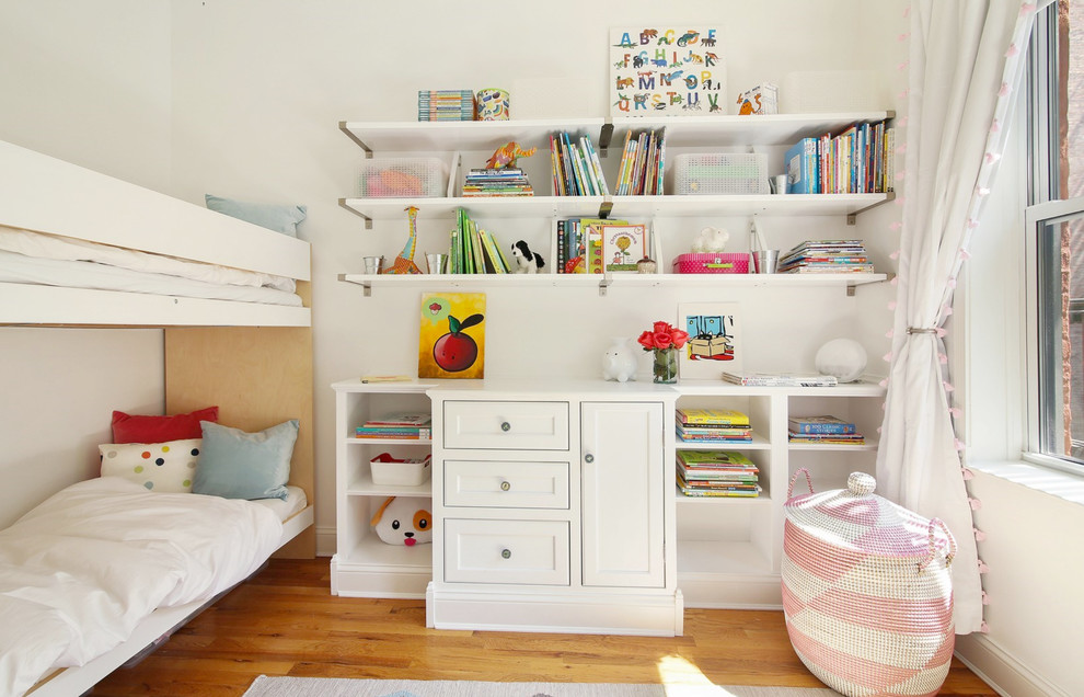 This is an example of a transitional kids' bedroom for girls in Los Angeles with white walls, medium hardwood floors and brown floor.