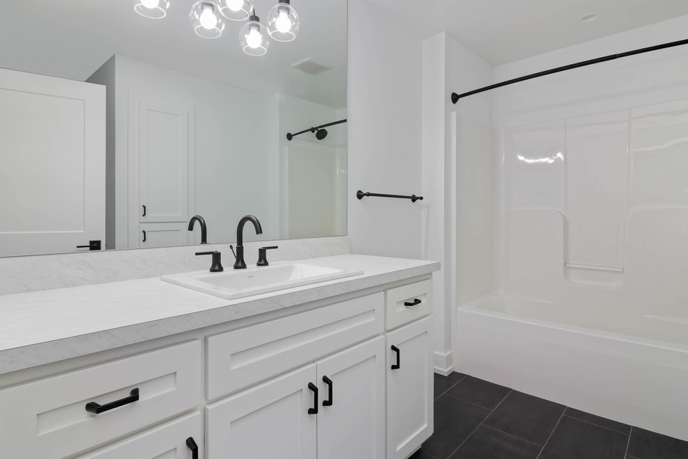 Inspiration for a mid-sized country 3/4 bathroom in Grand Rapids with shaker cabinets, white cabinets, an alcove tub, a shower/bathtub combo, white walls, slate floors, a drop-in sink, marble benchtops, black floor and a shower curtain.