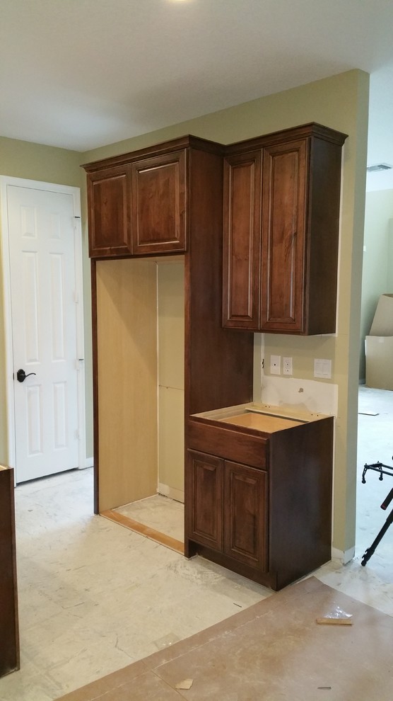 Example of a mid-sized transitional l-shaped eat-in kitchen design in Miami with raised-panel cabinets, dark wood cabinets and an island