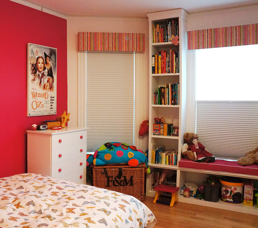 Traditional kids' bedroom in Boston with pink walls and medium hardwood floors for kids 4-10 years old and girls.