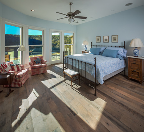 Country master bedroom in Austin with blue walls, medium hardwood floors and no fireplace.