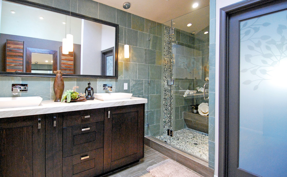 Mid-sized contemporary master bathroom in Orange County with a vessel sink, raised-panel cabinets, dark wood cabinets, marble benchtops, a double shower, a one-piece toilet, green tile, pebble tile, beige walls and porcelain floors.